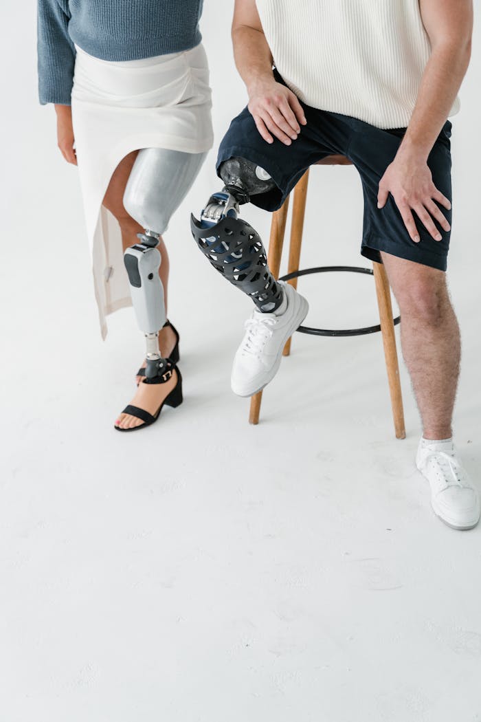 services-04 Two adults with prosthetic legs captured in a studio setting, highlighting technology and diversity.